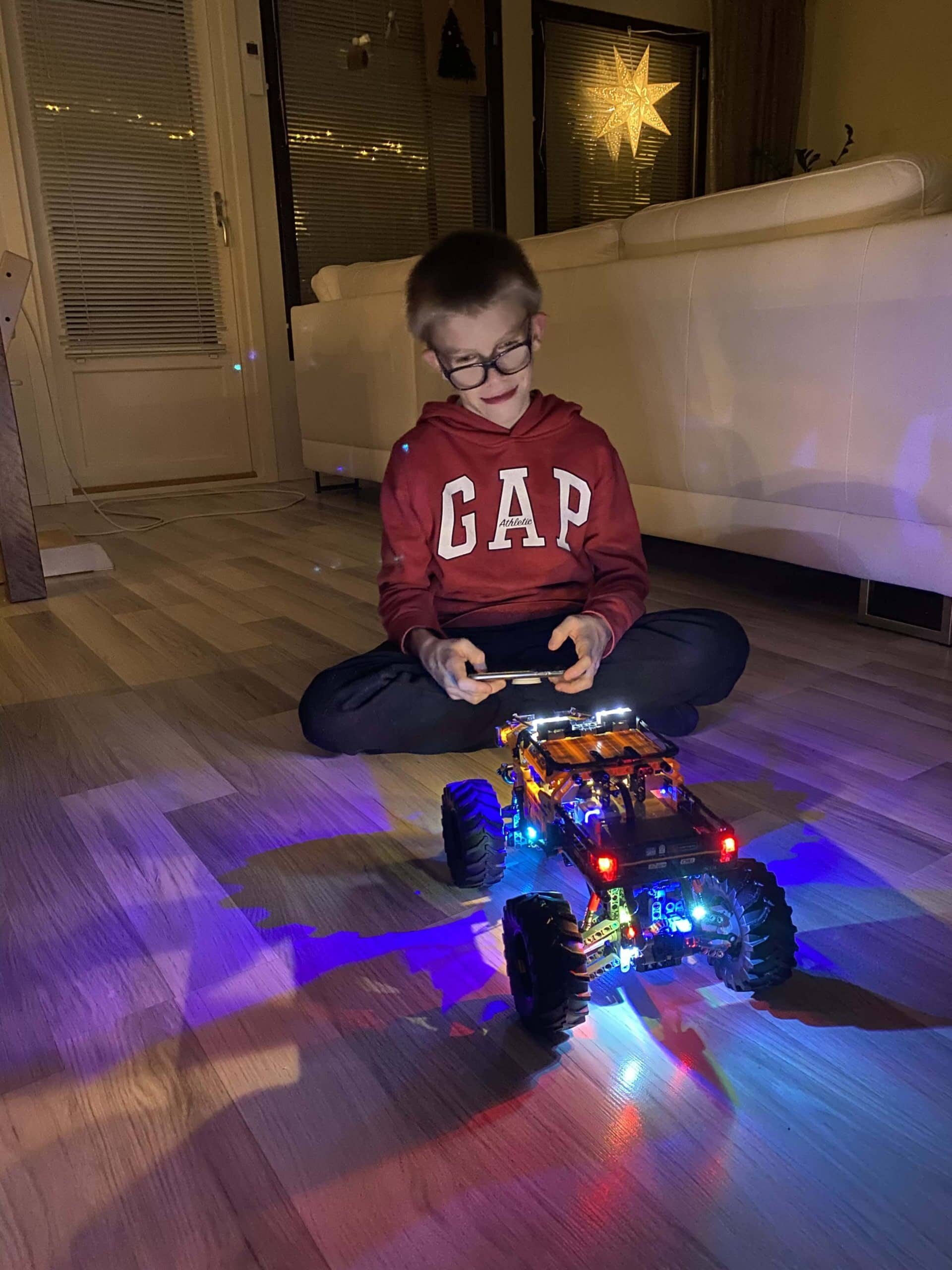 Kid sitting in the dark playing with a light up remote car