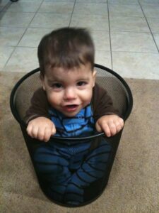 Toddler scrunched into a bin